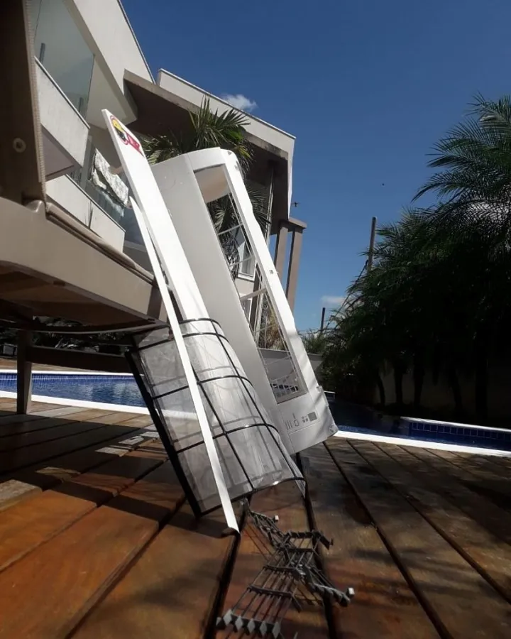 Condensadora sendo içada até a varanda de uma casa