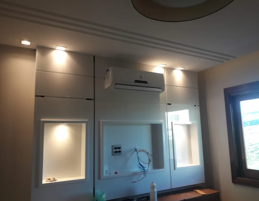 Split hi wall instalado acima de um painel com nichos iluminados